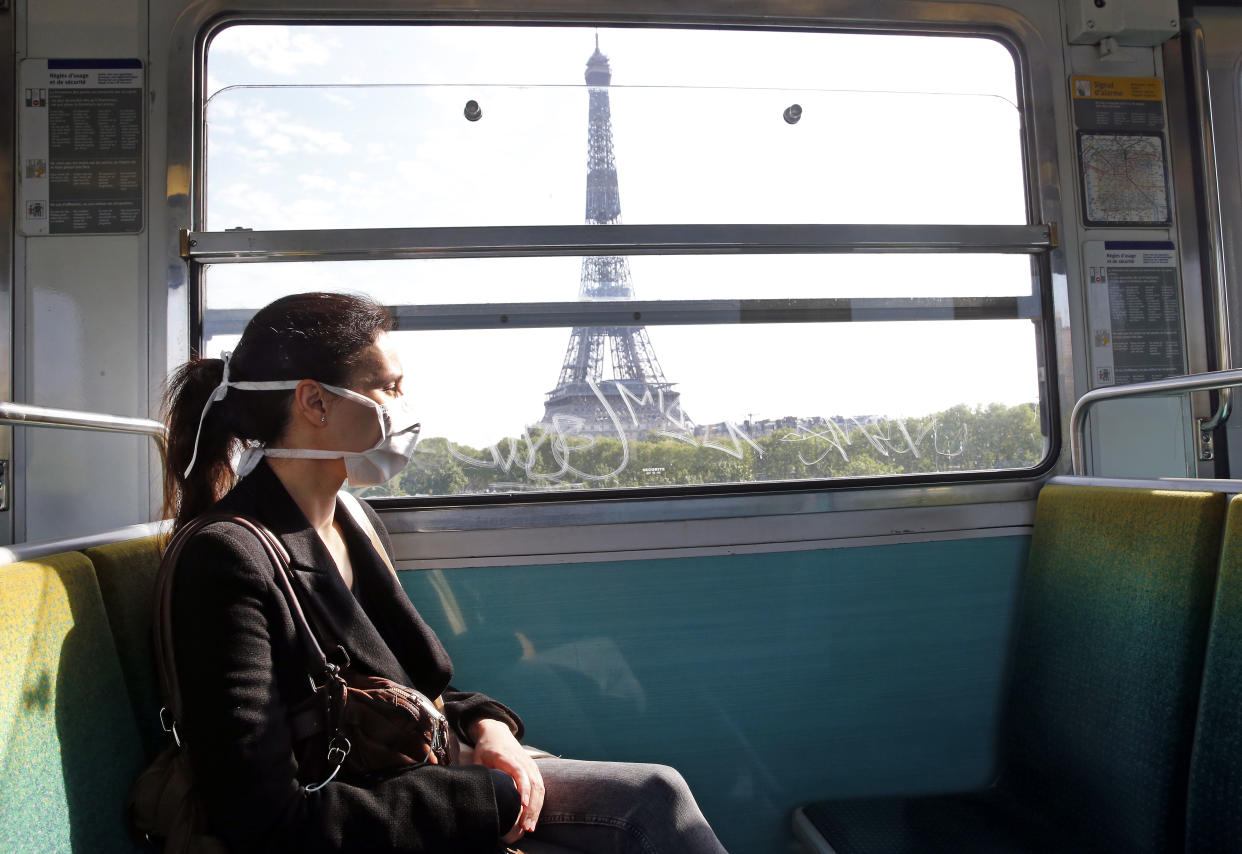 PARIS, FRANCE - APRIL 24: A passenger wearing a protective face mask is seen in a subway train as she passes in front the Eiffel Tower as the lockdown continues due to the coronavirus outbreak (COVID 19) on April 24, 2020 in Paris, France. After a meeting between the Head of State Emmanuel Macron and the mayors, the Elysee Palace said that the wearing of the mask will probably be compulsory in public transport, starting on May 11. The Coronavirus (COVID-19) pandemic has spread to many countries across the world, claiming over 191,000 lives and infecting over 2.7 million people. (Photo by Chesnot/Getty Images)