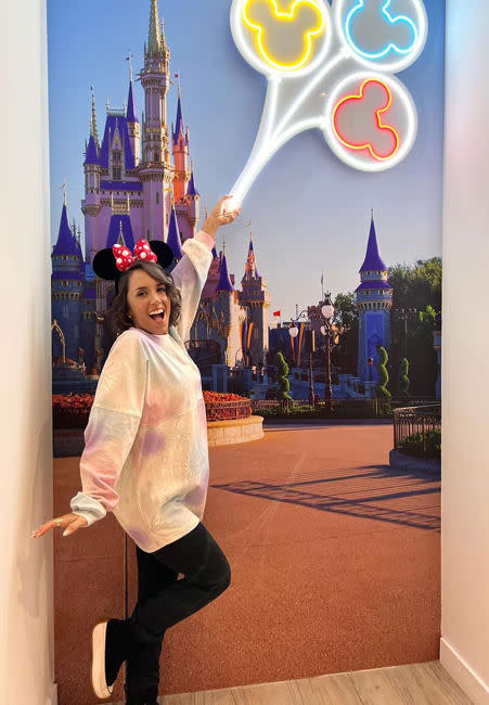 janette wears a mini mouse ears headband and jumps joyfully