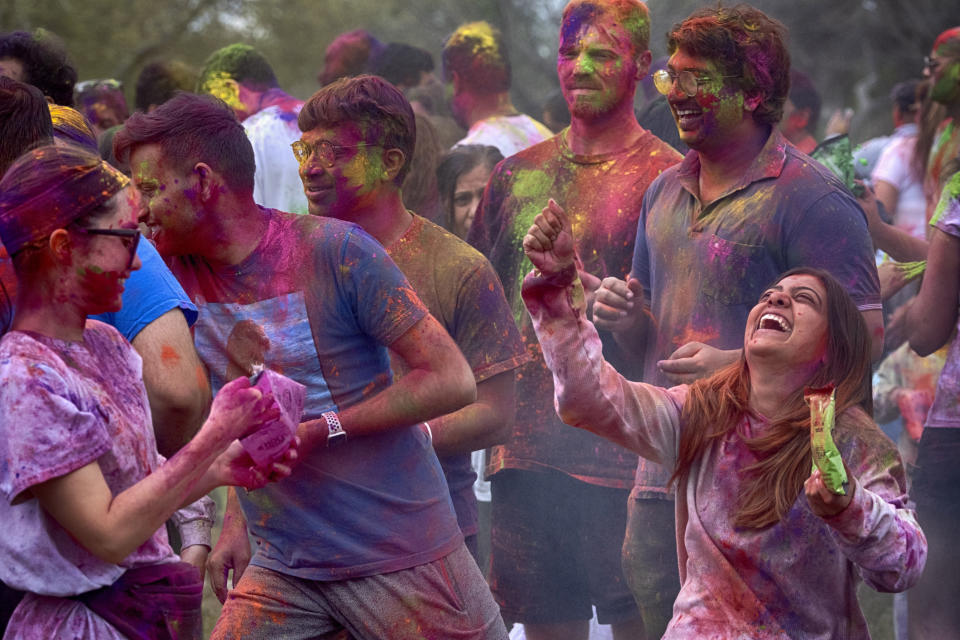 People dance and throw colored powder as they celebrate Holi, the Hindu festival of colors, in the Encino section of Los Angeles on Sunday, March 24, 2024. (AP Photo/Richard Vogel)