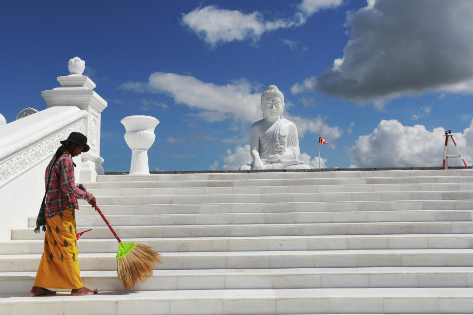 A laborer sweeps near the sitting Maravijaya Buddha statue made with marble rock, Friday, July 21, 2023, in Naypyitaw, Myanmar. The Maravijaya Buddha statue is said to be the world’s highest sitting marble Buddha image according to local media. (AP Photo/Aung Shine Oo)