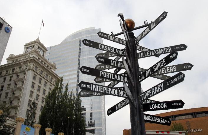 A sign with multiple worldwide destinations is shown in downtown Portland, Ore., Wednesday, Sept. 19, 2012. Researchers at Portland State University found that the Portland atmosphere and culture is a magnet for the young and college educated, even though a disproportionate share of them are working in part-time jobs or positions that don’t require a college degree. (AP Photo/Don Ryan)