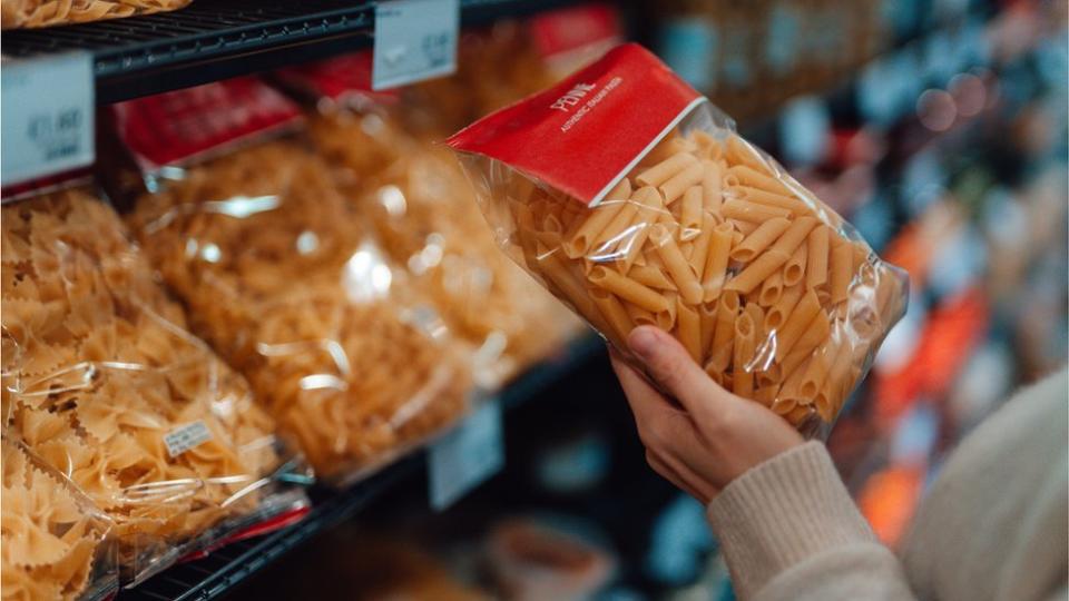 Persona comprando pasta en el supermercado.