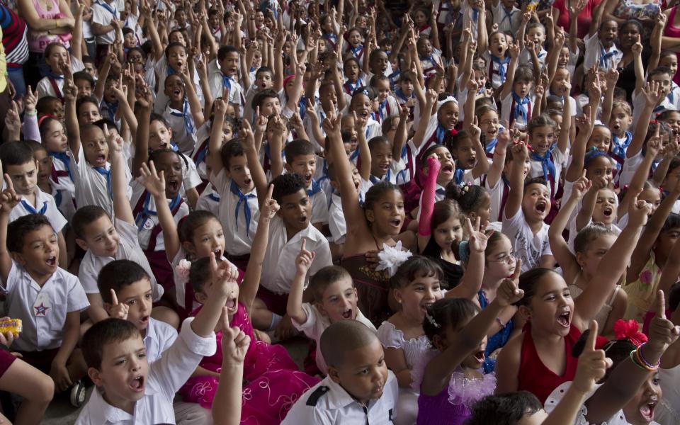 Young students cheer during a celebration to mark the anniversaries of the Organization of Cuban Pioneers and of the Union of Communist Youth at the Angela Landa elementary school in Old Havana, Cuba, Friday, April 4, 2014. Cuban schoolchildren are referred to as "pioneers," and the organization was founded in 1961 to encourage the values of education and social responsibility among children and adolescents. (AP Photo/Franklin Reyes)