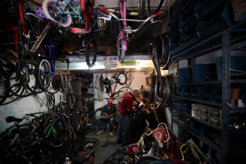 Bicycle repairman Pepe Segura works at his shop in Caracas