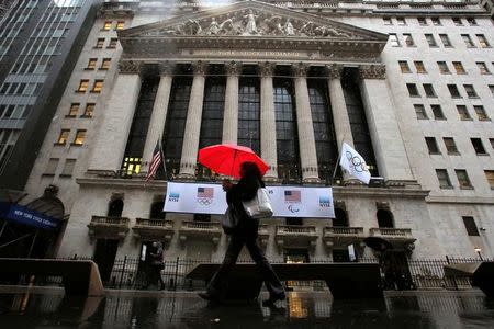 People walk by the New York Stock Exchange (NYSE) during the morning commute in the financial district during a winter nor'easter in New York City, U.S., March 2, 2018. REUTERS/Andrew Kelly