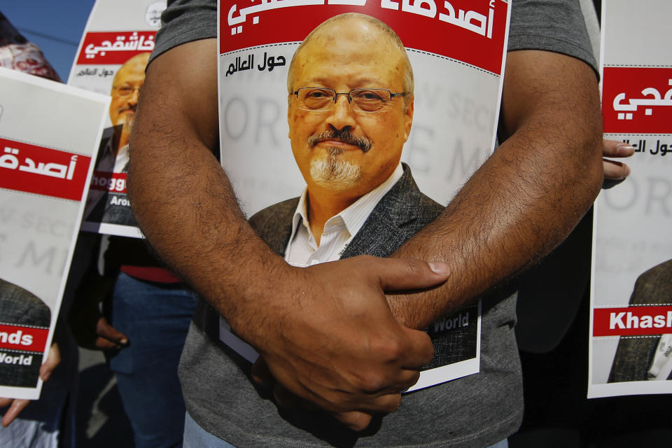 People hold posters of slain Saudi journalist Jamal Khashoggi, near the Saudi Arabia consulate in Istanbul, marking the two-year anniversary of his death, Friday, Oct. 2, 2020. The gathering was held outside the consulate building, starting at 1:14 p.m. (1014 GMT) marking the time Khashoggi walked into the building where he met his demise. The posters read in Arabic:' Khashoggi's Friends Around the World'. (AP Photo/Emrah Gurel)