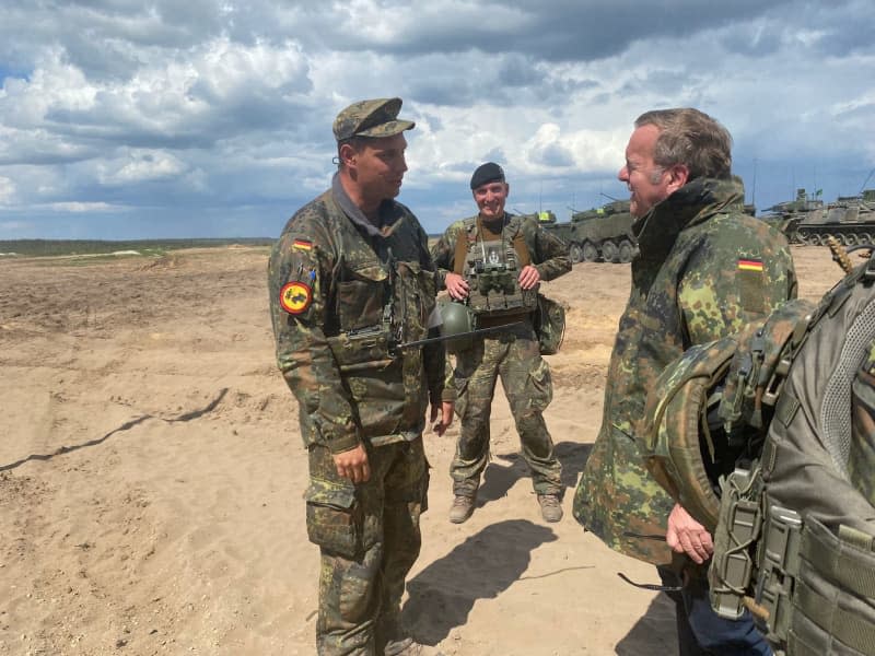 Boris Pistorius (R), Germany's Defence Minister, talks to German soldiers at the military training area. Alexander Welscher/dpa