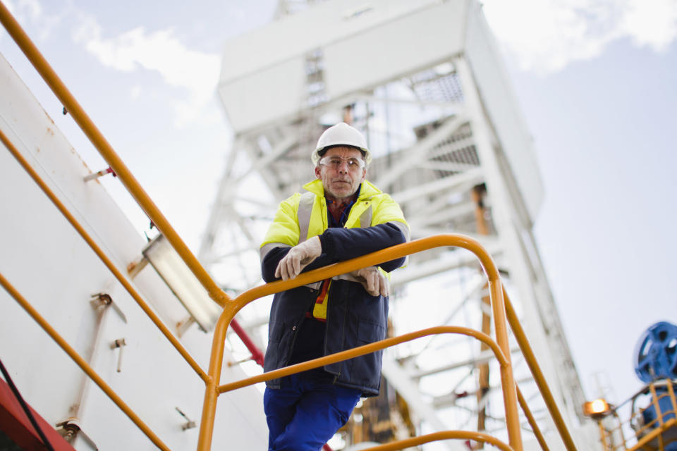 Man looking down from an oil rig