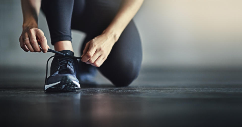 Cropped shot of a woman tying her shoelaces before a workout