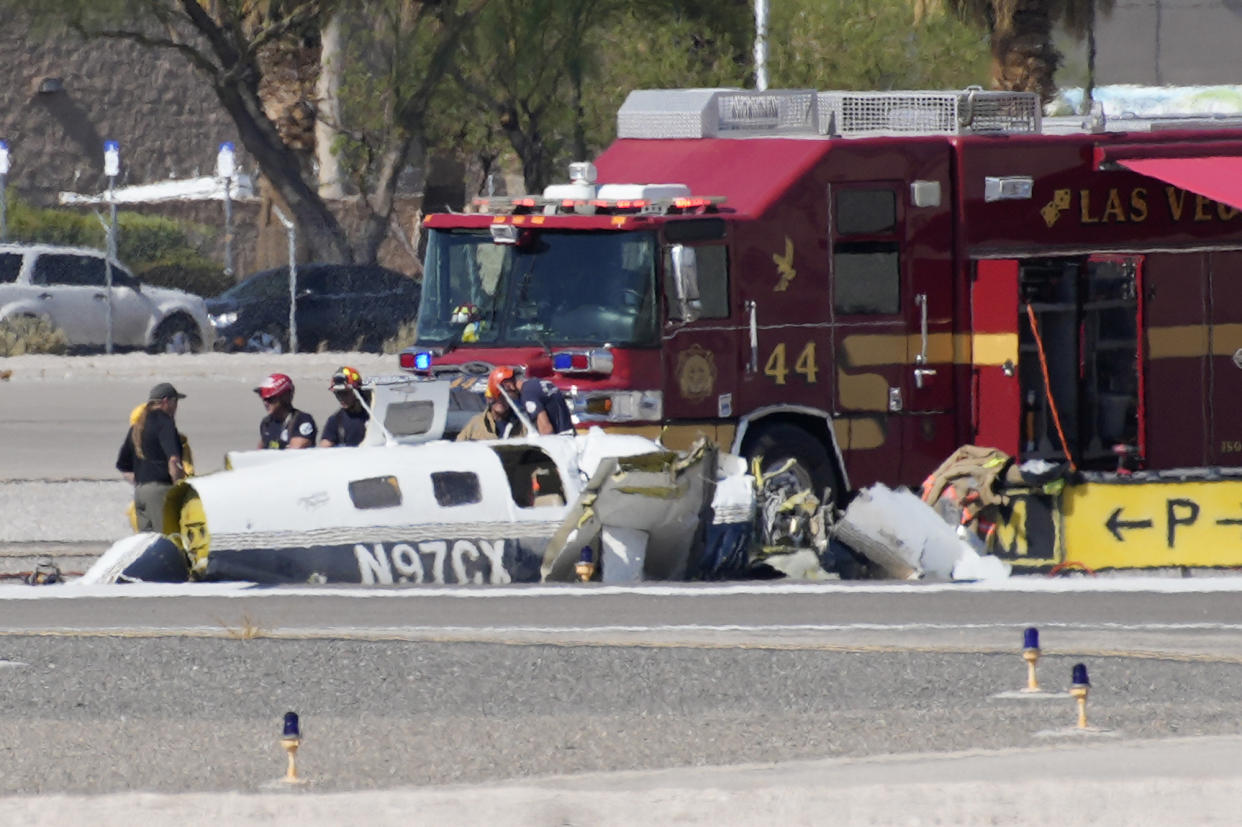 Officials investigate the wreckage of a plane at the site of a fatal crash at the North Las Vegas Airport, Sunday, July 17, 2022, in North Las Vegas, Nev. (AP Photo/John Locher)