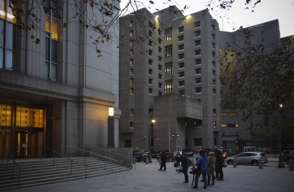 Reporters wait outside federal court for the exit of two jail guards, following their arraignment charge of falsifying prison records about their monitoring of Jeffrey Epstein the night he killed himself at the Metropolitan Correctional Center jail, center, Tuesday Nov. 19, 2019, in New York. (AP Photo/Bebeto Matthews)