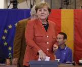 FILE - In This Sunday, Sept. 24, 2017 file photo, German Chancellor Angela Merkel casts her vote for the federal parliament election in Berlin, Germany. German voters elect a new parliament on Sunday, Sept. 26, 2021, a vote that will determine who succeeds Chancellor Angela Merkel after her 16 years in power. (AP Photo/Matthias Schrader, File)