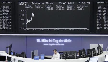 A trader stands under the German share price index DAX board at the stock exchange in Frankfurt March 3, 2015. REUTERS/Stringer