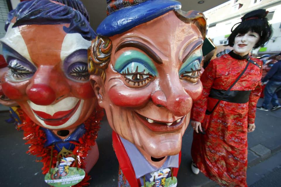 A carnival reveller walks past papier mache figures during the postponed “Rosenmontag” (Rose Monday) parade in Mainz, Germany, May 8, 2016, after the original parade in February was cancelled due to severe weather. The parade also marks the 200 years of Rheinhessen (a region of Rhineland-Palatinate). (Ralph Orlowski/REUTERS