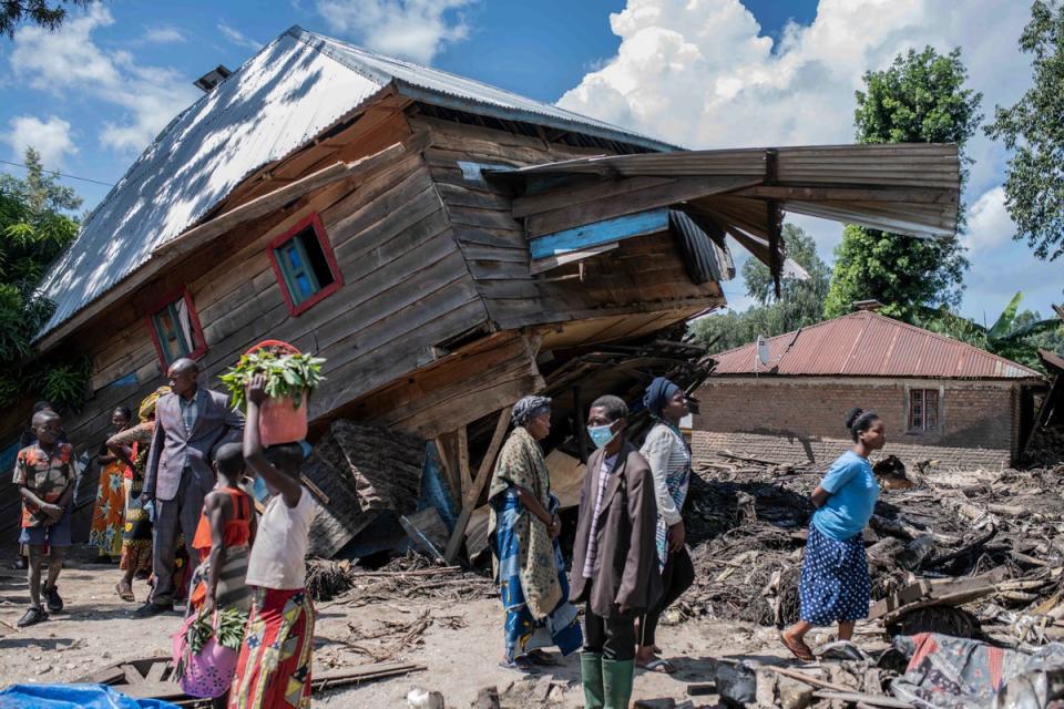 Villagers gather near a destroyed home in Nyamukubi, near Kivu Lake, on Saturday following  devastating flooding and landslides (AP)