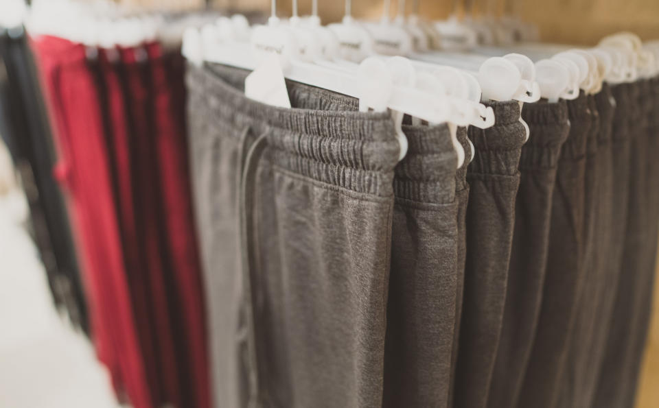 Sweatpants hung on hangers at a store