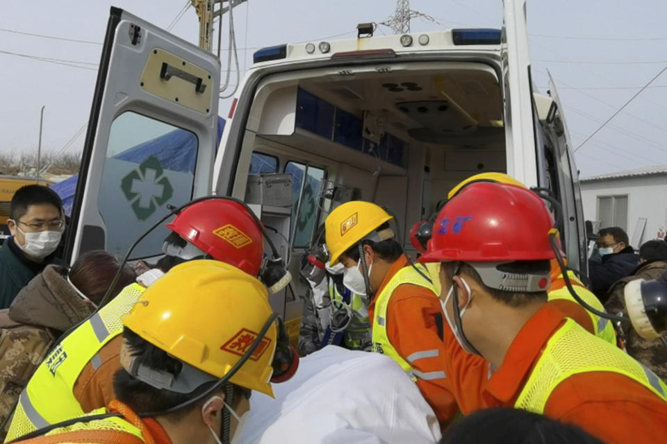 In this photo released by Xinhua News Agency, rescuers carry a miner who was trapped in a gold mine in Qixia City in east China's Shandong Province, Sunday, Jan. 24, 2021. Rescuers in China on Sunday lifted several trapped miners to the surface who were trapped for two weeks after an explosion in a northern gold mine, state media reported. (Luan Qincheng/Xinhua via AP)