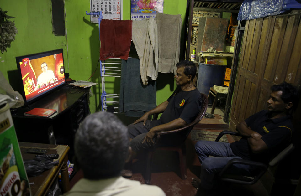 Sri Lankans watch a televised speech by president Maithripala Sirisena at their residence in Colombo, Sri Lanka, Sunday, Oct. 28, 2018. (AP Photo/Eranga Jayawardena)