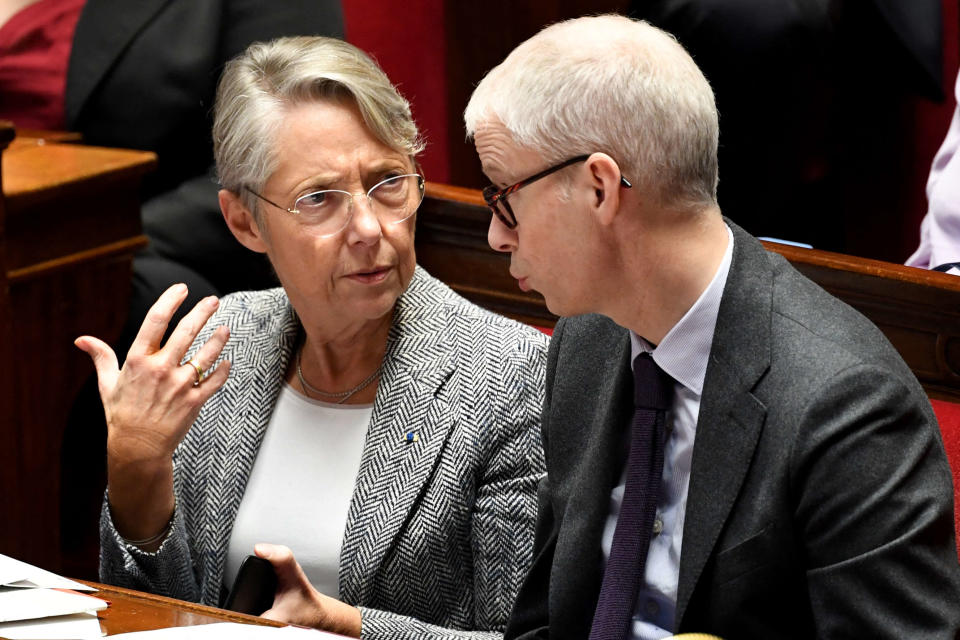 French Prime Minister Elisabeth Borne (L) speaks with French Junior Minister for the Relations with the Parliament Franck Riester (R) during a session of questions to the government at the National Assembly, French Parliament lower house, in Paris on January 24, 2023. (Photo by BERTRAND GUAY / AFP)