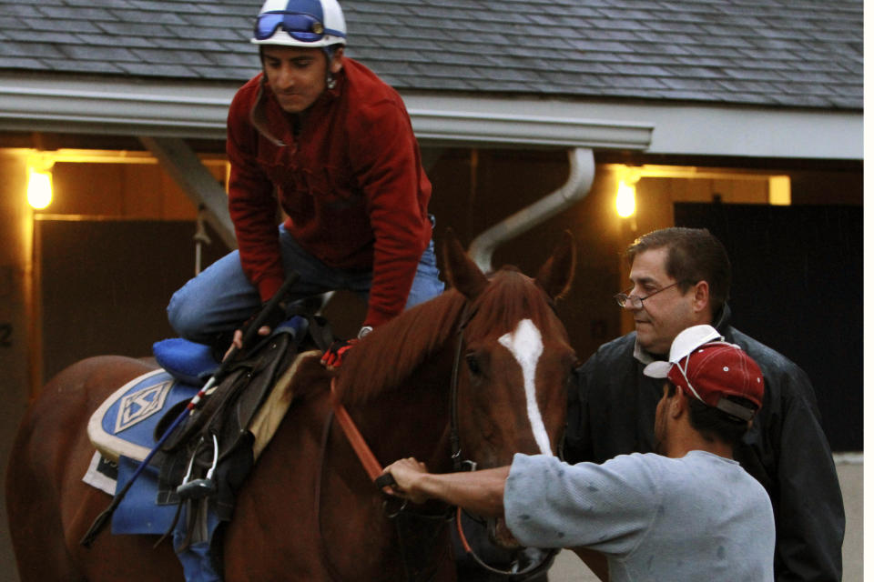 FILE - Trainer John Sadler, rear right, watches as jockey Rafael Bejarano mounts a horse before a workout at Churchill Downs in Louisville, Ky., April 27, 2010. Undefeated Flightline and Rich Strike, upset winner of the Kentucky Derby, head a field of nine for the Breeders' Cup Classic. Trained by John Sadler, Flightline is 5-0 in his career. (AP Photo/Garry Jones, File)