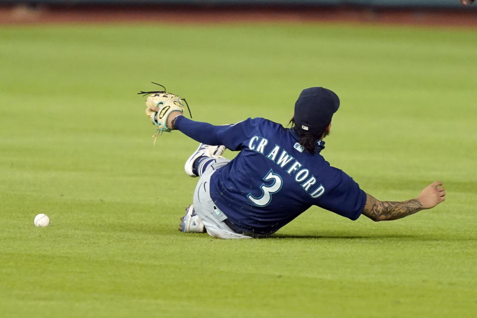 Seattle Mariners shortstop J.P. Crawford slides while trying to catch a single by Houston Astros' Josh Reddick during the fifth inning of a baseball game Friday, Aug. 14, 2020, in Houston. (AP Photo/David J. Phillip)