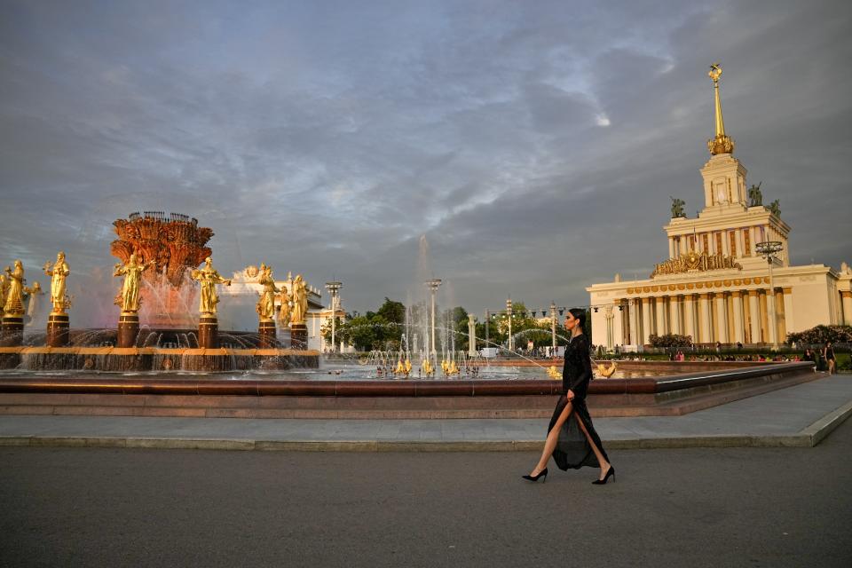 A model displays a creation by Russian designer Igor Chapurin at the fountain "Friendship of Peoples" during Fashion Week at VDNKh, The Exhibition of Achievements of National Economy in Moscow, Russia, Tuesday, June 21, 2022. More than 100 shows are being held during the week that began Monday as well as scores of speakers who are noted names in the Russian fashion industry. (AP Photo/Alexander Zemlianichenko)