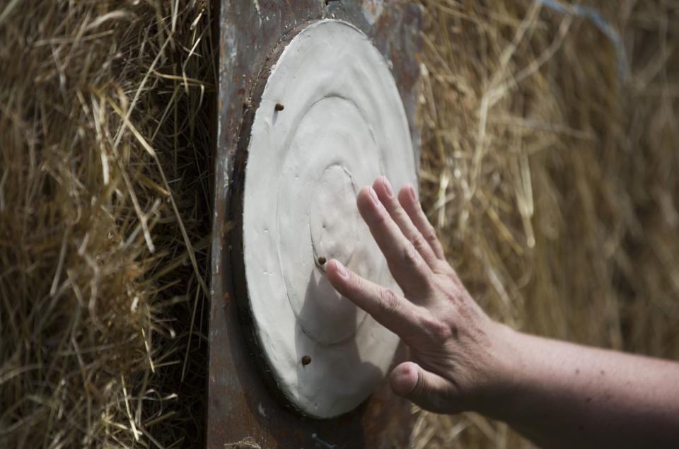 An official removes peas from a target during the 2014 World Pea Shooting Championship in Witcham, southern England July 12, 2014. The annual competition has been held in the village since 1971 and attracts participants from across the globe.