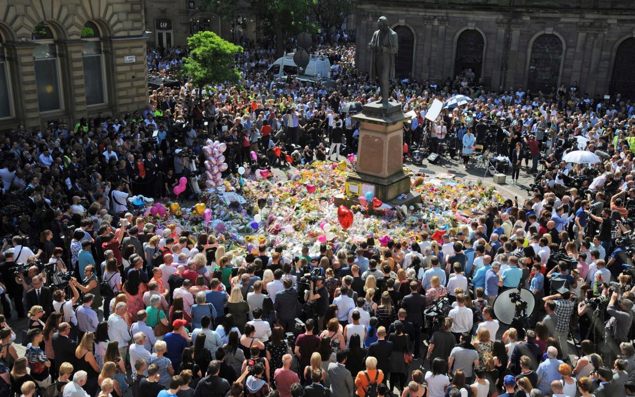 People attend a one minute silence to the victims of Monday's explosion at St Ann's Square in Manchester, England. - AP