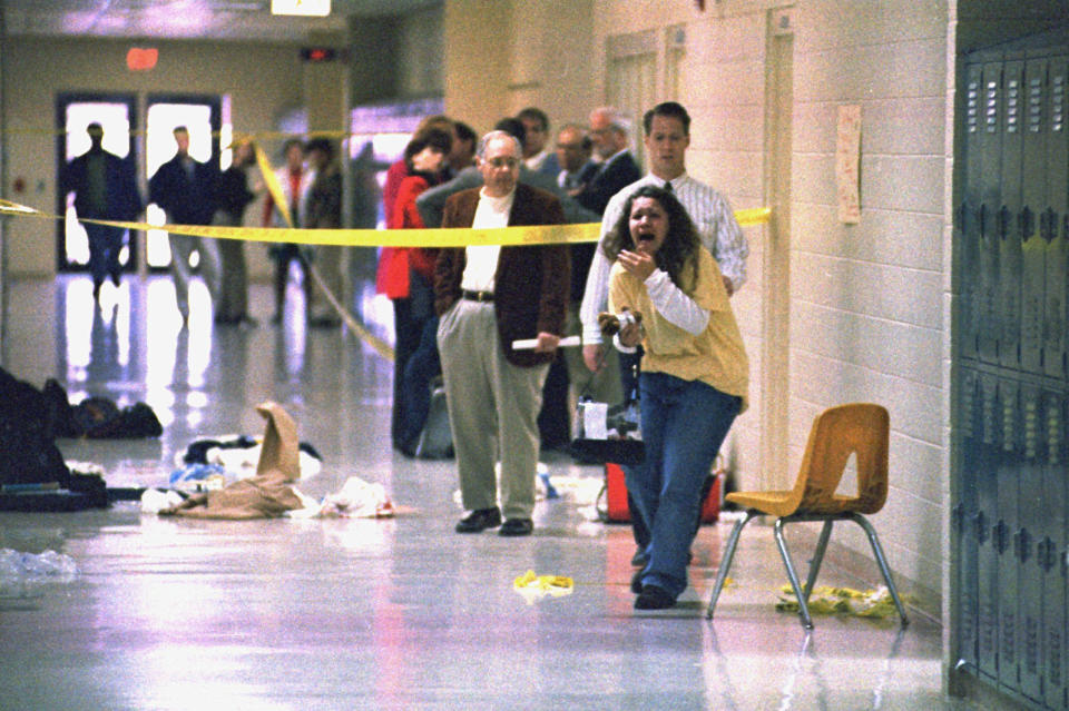 FILE - A Heath High School student screams at seeing the scene of a shooting at the school where fellow student Michael Carneal opened fire, leaving three students dead and five wounded Dec. 1, 1997, near Paducah, Ky. In the quarter century that has passed, school shootings have become a depressingly regular occurrence in the U.S. Carneal's upcoming parole hearing in September 2022, raises questions about the appropriate punishment for children who commit heinous crimes. Even if they can be rehabilitated, many wonder if it is fair to the victims for them to be released. (Steve Nagy/The Paducah Sun via AP, File)