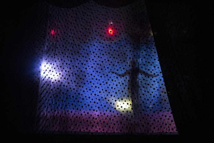 The silhouette of an artist is seen through a stage curtain during a Timoteo Circus show, on the outskirts of Santiago, Chile, Saturday, Dec. 10, 2022. Although it is called a circus, it is more of a sexual diversity show with humor, song and dance under a big top. (AP Photo/Esteban Felix)