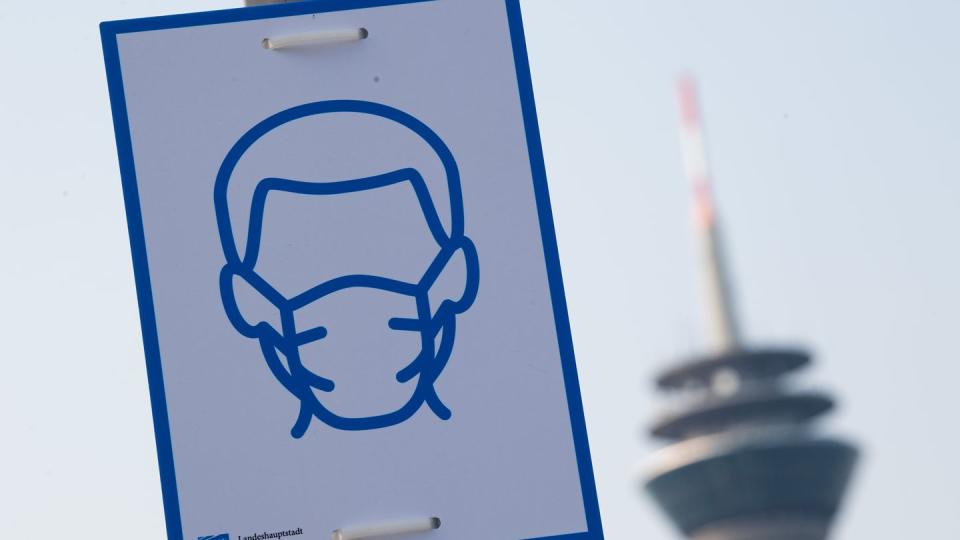 Ein Piktogramm mahnt in Düsseldorf das Einhalten der Maskenpflicht an.