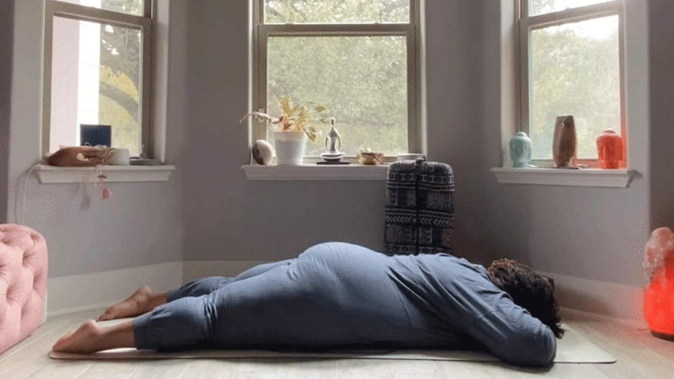Woman lying on her belly in Savasana on the floor of her bedroom