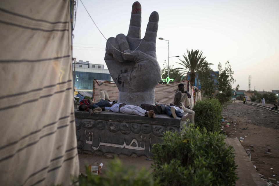 Protesters rest on the pedestal of a sculpture during a sit-in at Armed Forces Square in Khartoum, Sudan, Saturday, April 27, 2019. The Umma party of former Prime Minister Sadiq al-Mahdi, a leading opposition figure, said the protesters will not leave until there is a full transfer of power to civilians. (AP Photos/Salih Basheer)