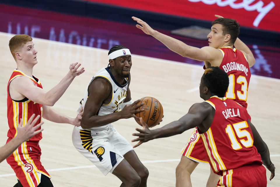 Indiana Pacers' Caris LeVert (22) looks for a shot between Atlanta Hawks' Bogdan Bogdanovic (13), Clint Capela (15) and Kevin Huerter during the second half of an NBA basketball game Thursday, May 6, 2021, in Indianapolis. (AP Photo/Darron Cummings)