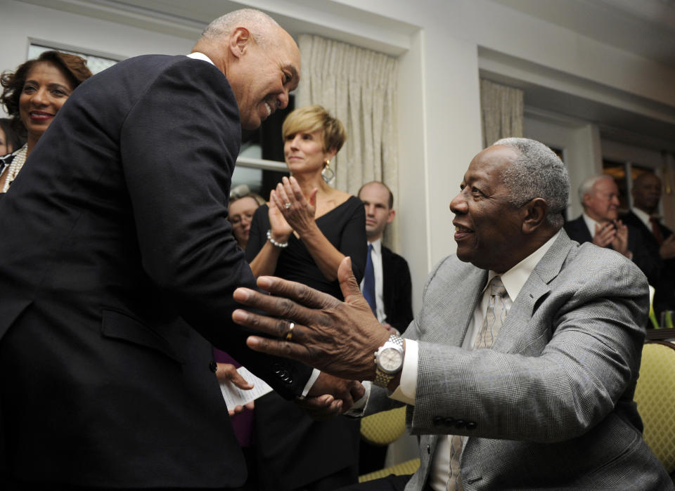 Baseball Hall of Famer Hank Aaron, right, shakes hands with Reggie Jackson at a reception for Aaron, Friday, Feb. 7, 2014, in Washington. Aaron turned 80 this week and is being celebrated with a series of events in Washington. (AP Photo/Nick Wass)