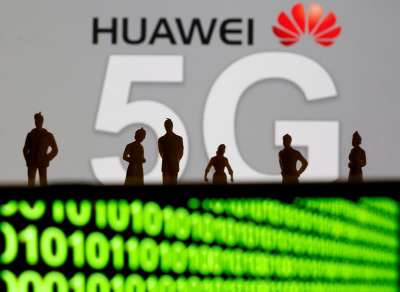 FILE PHOTO: Small toy figures are seen in front of a displayed Huawei and 5G network logo in this illustration picture