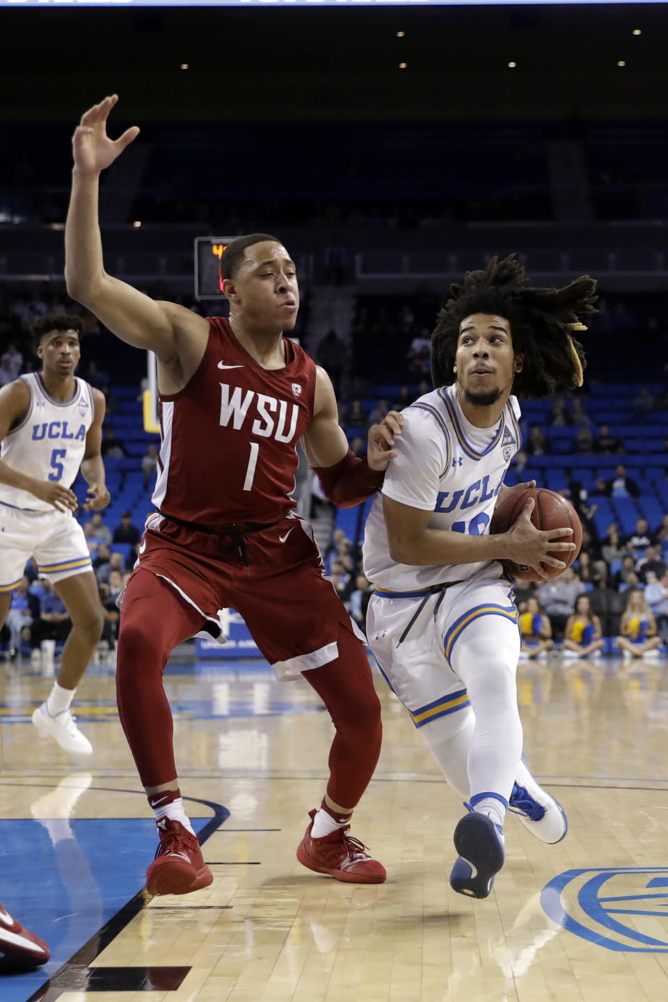 UCLA guard Tyger Campbell, right, is defended by Washington State guard Jervae Robinson (1) during the first half of an NCAA college basketball game Thursday, Feb. 13, 2020, in Los Angeles. (AP Photo/Marcio Jose Sanchez)
