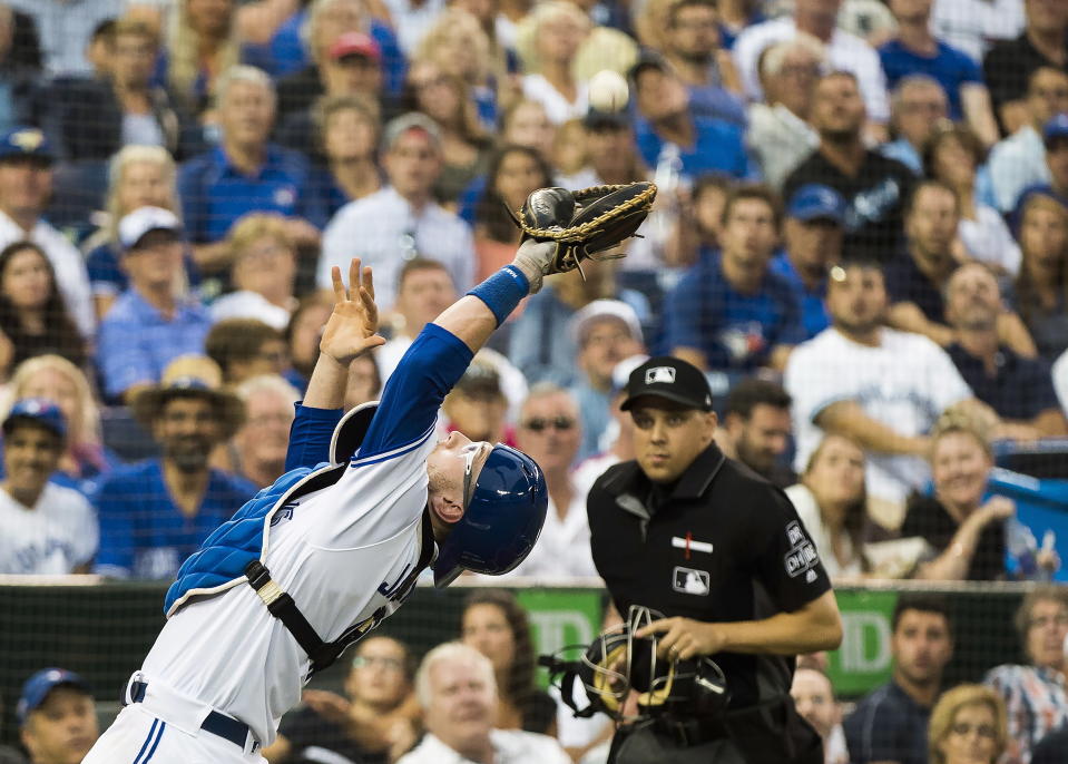 Toronto Blue Jays catcher Danny Jansen (9) makes a pop up catch behind home plate to out Baltimore Orioles third baseman Renato Nunez (39) during third inning baseball action in Toronto on Monday, Aug. 20, 2018. (Nathan Denette/The Canadian Press via AP)