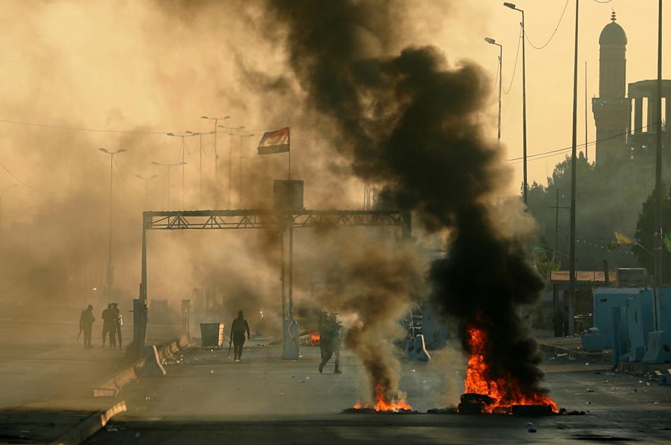 Iraqi security forces fire tear gas to disperse anti-government protesters who set fires and close a street during a demonstration in Baghdad, Iraq, Saturday, Oct. 5, 2019. The spontaneous protests which started Tuesday in Baghdad and southern cities were sparked by endemic corruption and lack of jobs. Security forces responded with a harsh crackdown, with dozens killed. (AP Photo/Hadi Mizban)