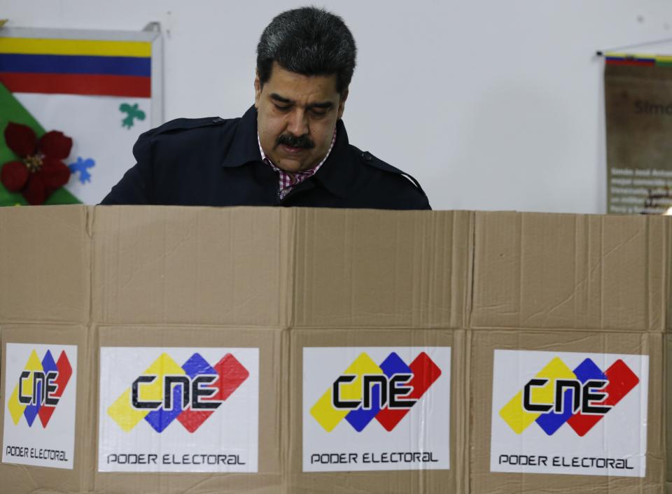 Venezuela's President Nicolas Maduro votes during local elections in Caracas, Venezuela, Sunday, Dec. 9, 2018. Venezuelans head to the polls Sunday to elect local city councils amid widespread apathy driven by a crushing economic crisis and threats of expulsion by opposition groups for candidates who participate in what they consider an "electoral farce." (AP Photo/Ariana Cubillos)