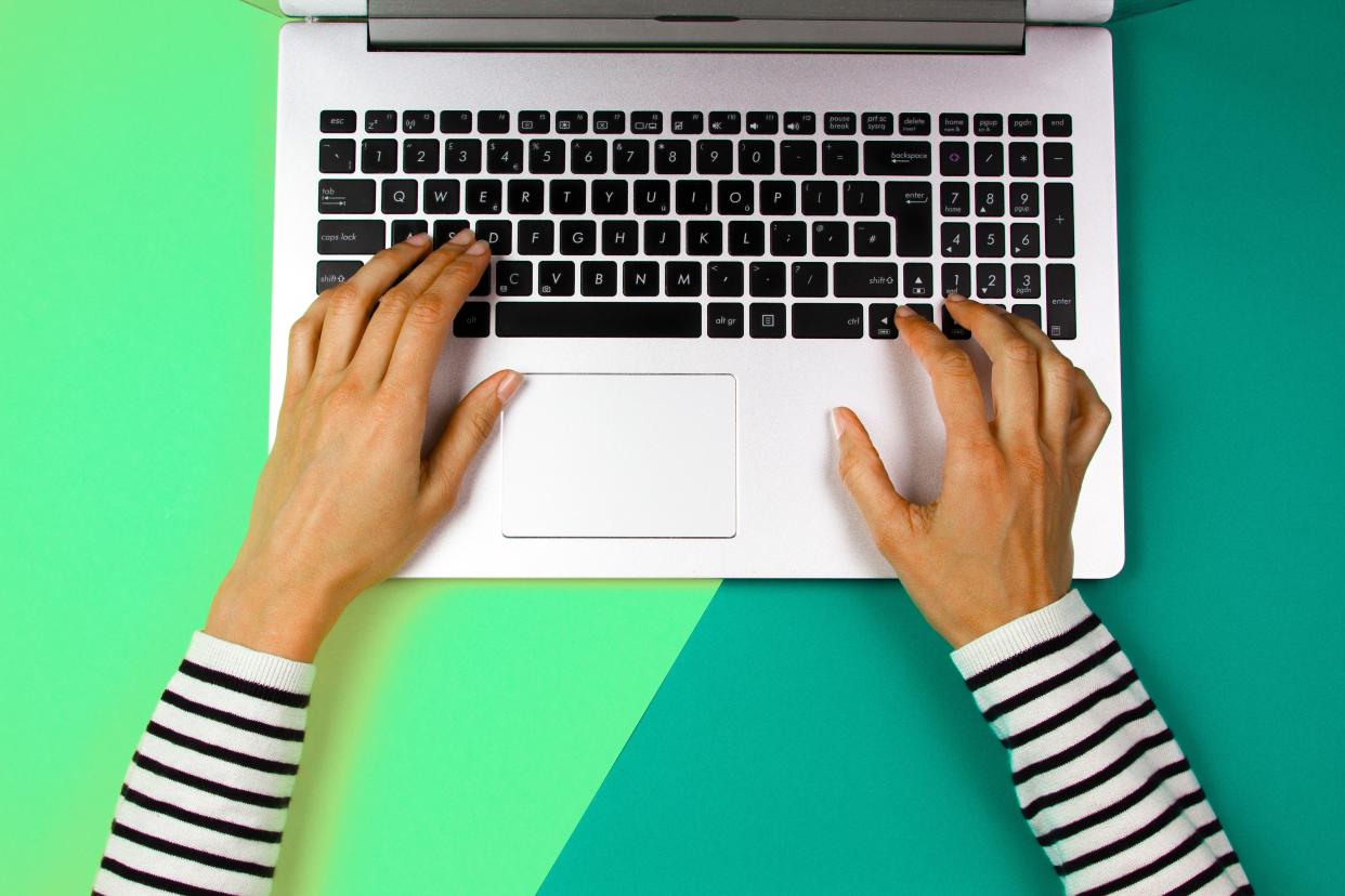 Woman using Apple Mac laptop over colorful background