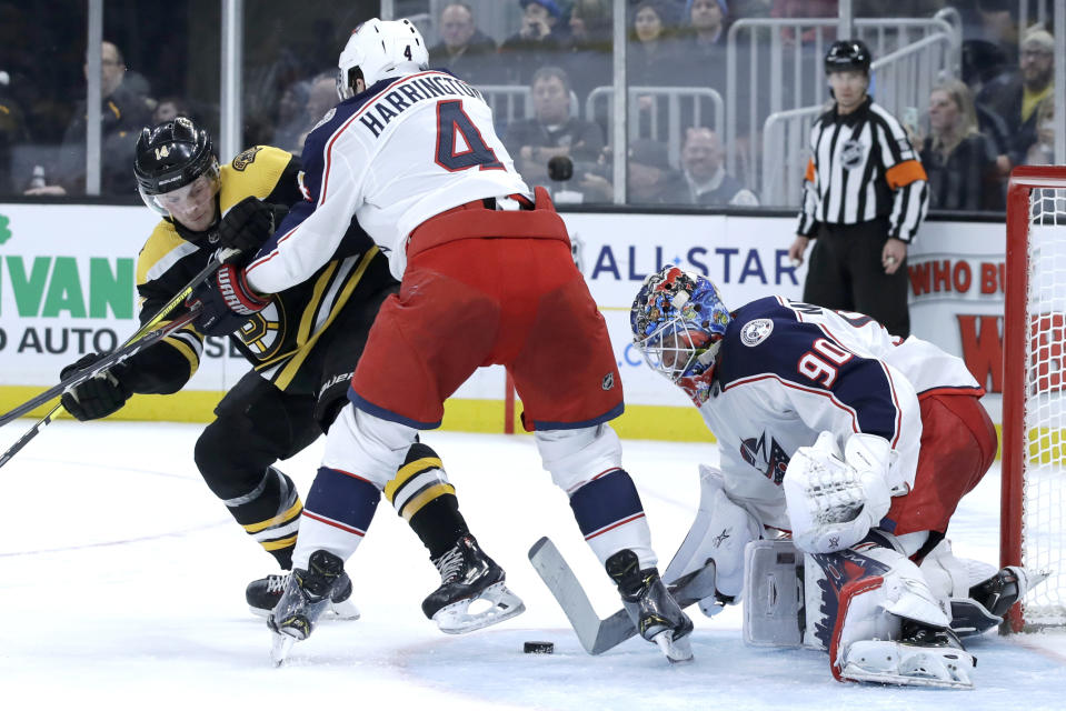 Columbus Blue Jackets defenseman Scott Harrington (4) keeps Boston Bruins right wing Chris Wagner (14) away from the puck as Blue Jackets goaltender Elvis Merzlikins (90) protects the net in the second period of an NHL hockey game, Thursday, Jan. 2, 2020, in Boston. (AP Photo/Elise Amendola)