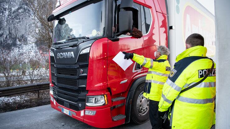 Zwei Bundespolizisten kontrollieren die Dokumente von aus Österreich kommenden Lkw-Fahrern an der Autobahn A93 bei Kiefersfelden in Richtung Deutschland. Foto: dpa