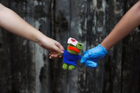 Secondary school students hold a Pepe the Frog plush toy with an eye patch as they form a human chain during a demonstration in Hong Kong