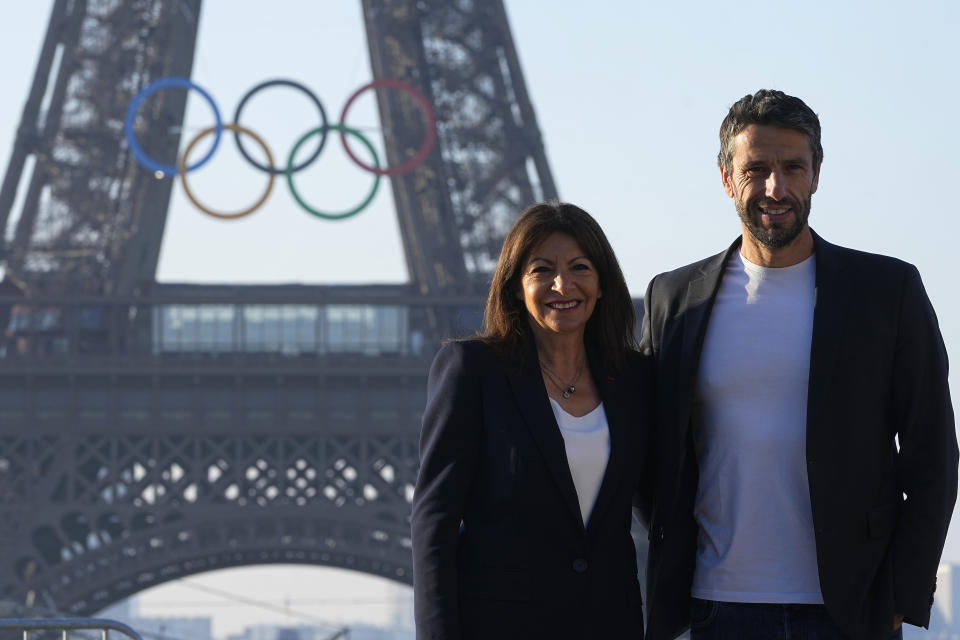 Paris mayor Anne Hidalgo and head of Paris 2024 Olympics Tony Estanguet pose in front of the Eiffel Tower Friday, June 7, 2024 in Paris. The Paris Olympics organizers mounted the rings on the Eiffel Tower on Friday as the French capital marks 50 days until the start of the Summer Games. The 95-foot-long and 43-foot-high structure of five rings, made entirely of recycled French steel, will be displayed on the south side of the 135-year-old historic landmark in central Paris, overlooking the Seine River. (AP Photo/Michel Euler)