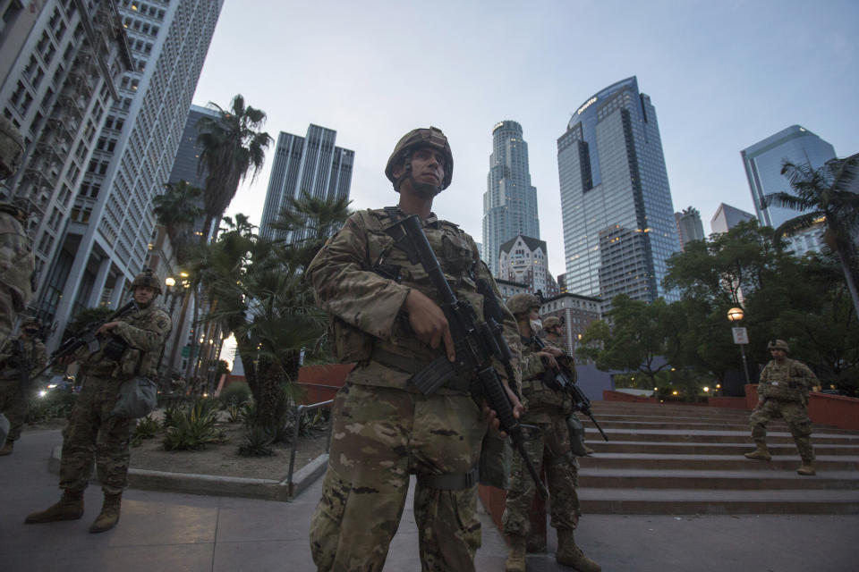 Members of California National Guard stand guard in Pershing Square, Sunday, May 31, 2020, in Los Angeles. The National Guard is patrolling Los Angeles as the city begins cleaning up after a night of violence by demonstrators that saw clash with officers and torch police vehicles and pillage stores. (AP Photo/Ringo H.W. Chiu)