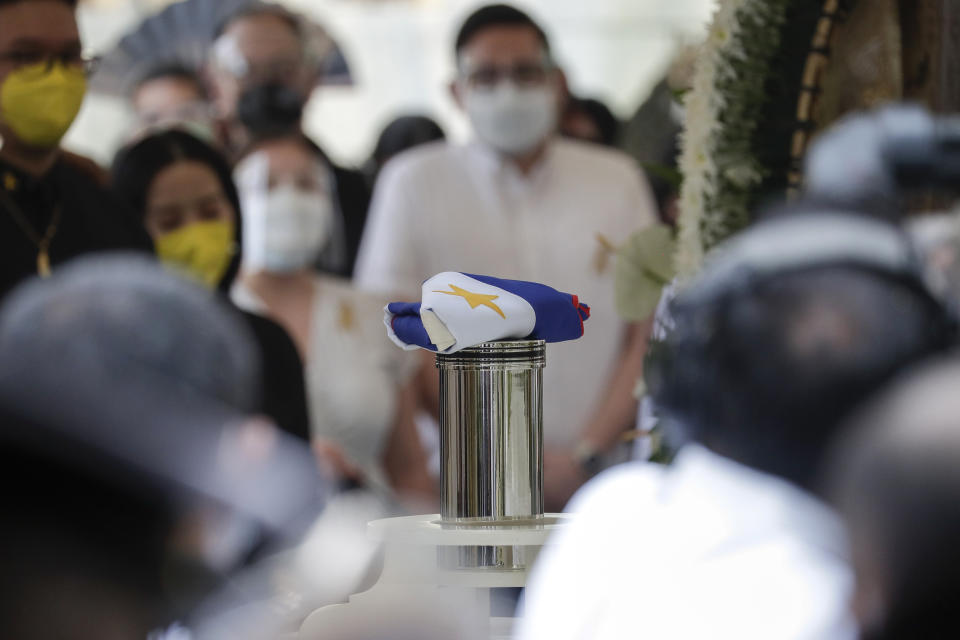 A Philippine flag is placed on top of the urn of former Philippine President Benigno Aquino III during state burial rites on Saturday, June 26, 2021 at a memorial park in suburban Paranaque city, Philippines. Aquino was buried in austere state rites during the pandemic Saturday with many remembering him for standing up to China over territorial disputes, striking a peace deal with Muslim guerrillas and defending democracy in a Southeast Asian nation where his parents helped topple a dictator. He was 61. (AP Photo/Aaron Favila)