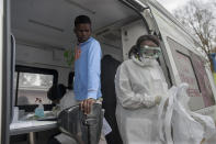 In this photo taken Friday, April 3, 2020 medical workers prepare to test a person, centre, for COVID-19 in a mobile testing unit in Yeoville, Johannesburg's. South Africa, one of the world's most unequal countries with a large population vulnerable to the new coronavirus, may have an advantage in the coronavrius outbreak, honed during years battling HIV and tuberculosis: the know-how and infrastructure to conduct mass testing. (AP Photo/Shiraaz Mohamed)