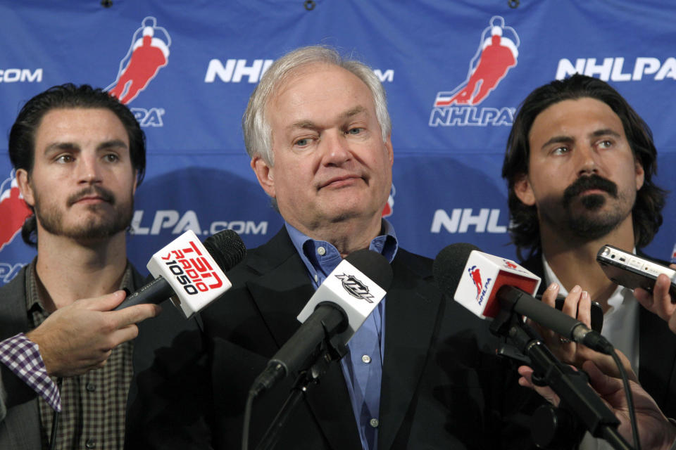 FILE - In this Sept. 12, 2012, file photo, National Hockey League Players' Association executive director Donald Fehr, center, is joined by players George Parros , left, and Kevin Westgath after meeting with NHL officials in New York. The NHLPA announces its decision whether to terminate the current collective bargaining agreement and set the clock ticking toward another potential work stoppage in 2020. (AP Photo/Mary Altaffer, File)