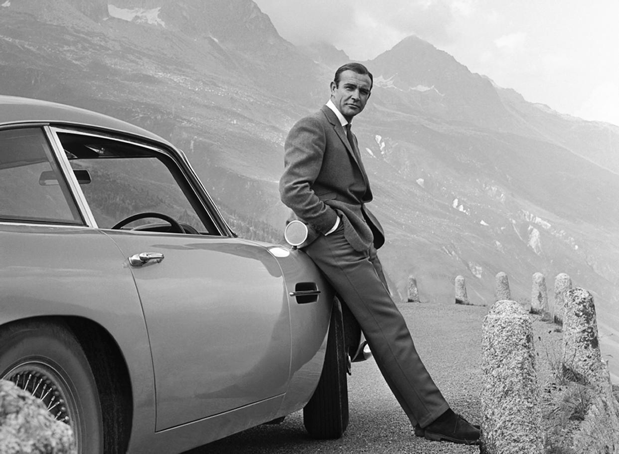 1964:  Actor Sean Connery poses as James Bond next to his Aston Martin DB5 in a scene from the United Artists release 'Goldfinger' in 1964  Photo by Michael Ochs Archives/Getty Images